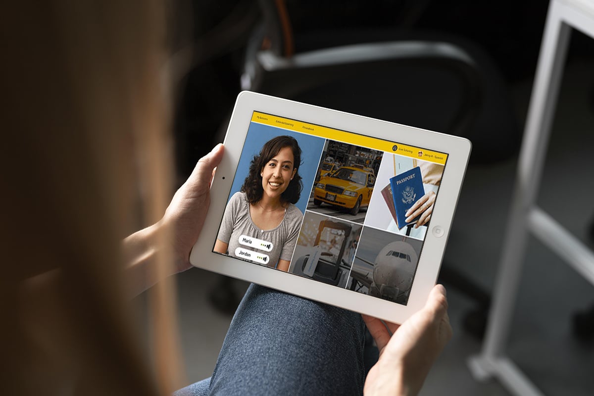 person is holding an ipad tablet with the rosetta stone program open