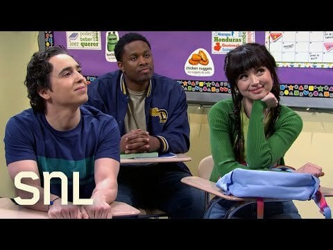 Marcell Hernandez and Ana de Armas sitting on two wooden desks