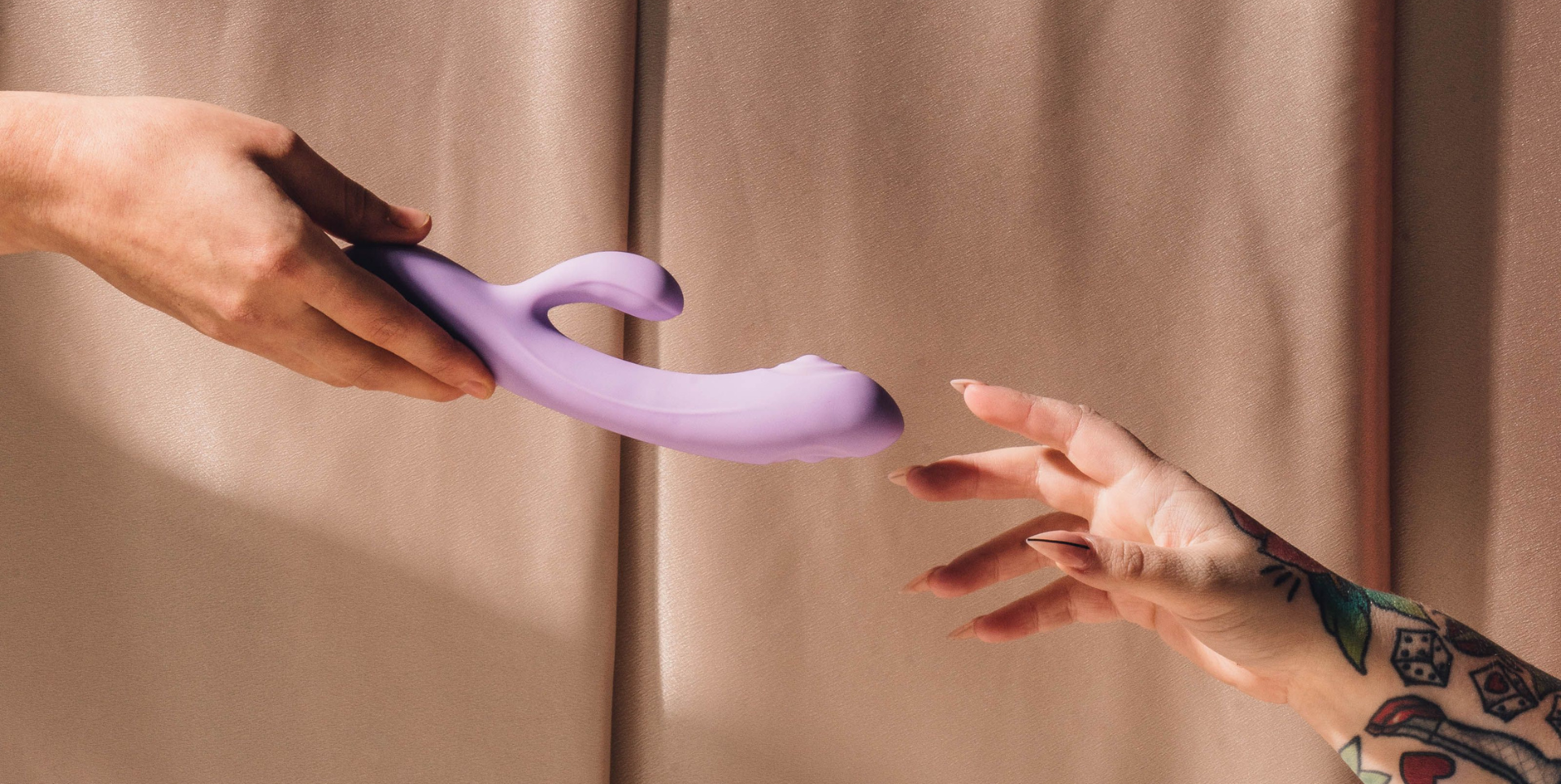 Two people's hands reaching for a vibrator