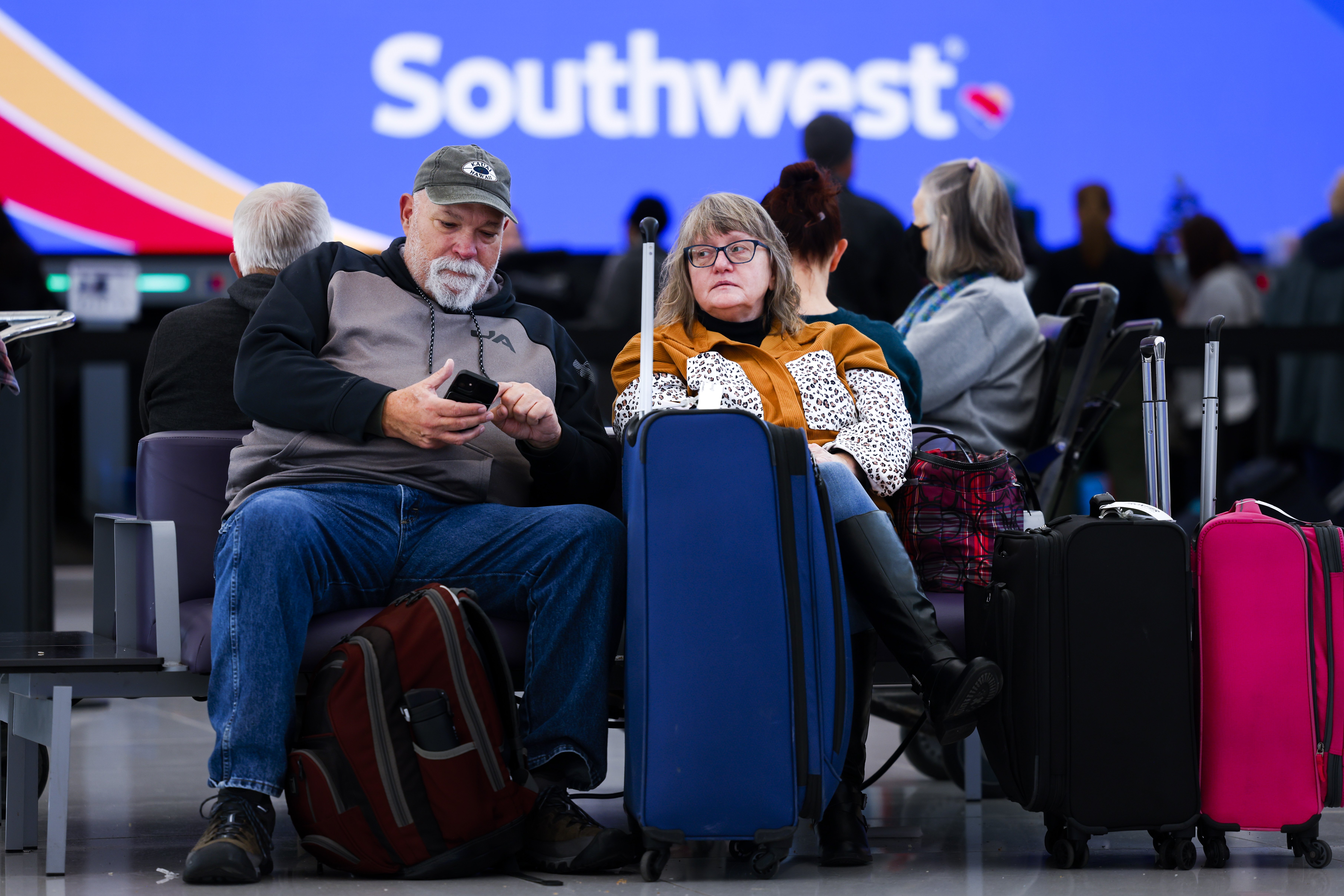 Airline passengers at a Southwest gate with their lugggage.
