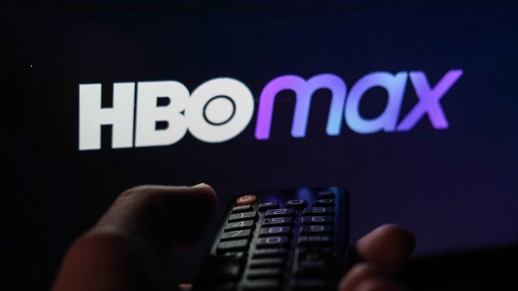 screen with hbo max logo and hand with tv remote