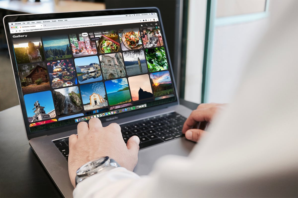 hands on top of a keyboard of a silver slim laptop, looking at photo files tiled across the screen