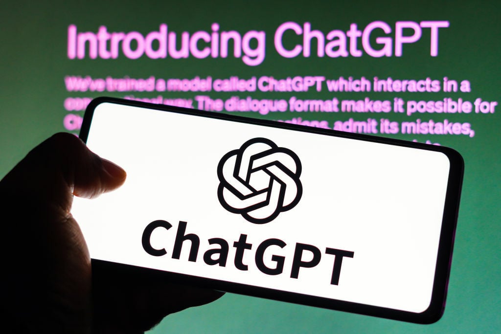 ChatGPT logo on a smartphone with the OpenAI logo behind it