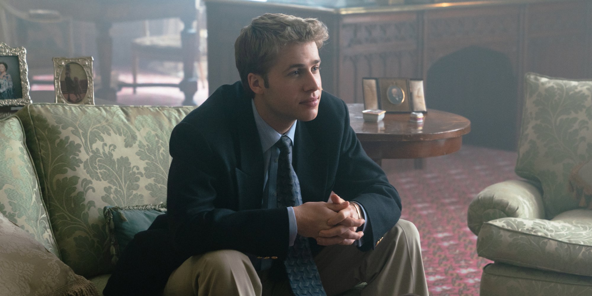 On "The Crown" an actor who looks like Prince William sits on a couch.
