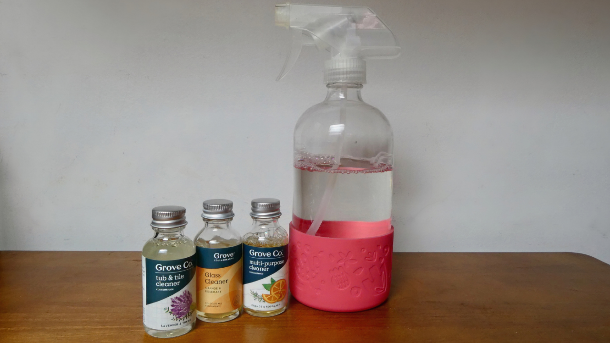 glass spray bottle with small bottle of grove cleaners