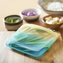 blue and yellow stasher bag with chopped cucumbers inside