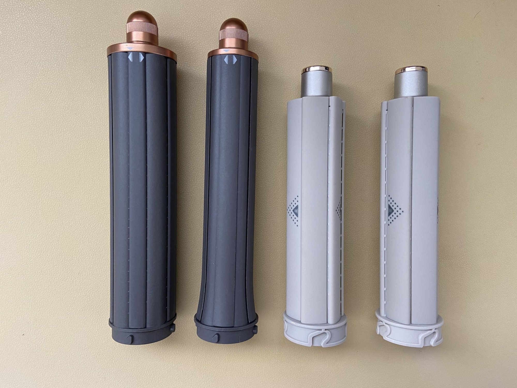 two dyson airwrap barrels next to two shark flexstyle barrels