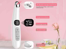 pink background with the massage wand in prominently displayed, showing its red LED light and temperature settings, next to a teacup and pink rose in a vase