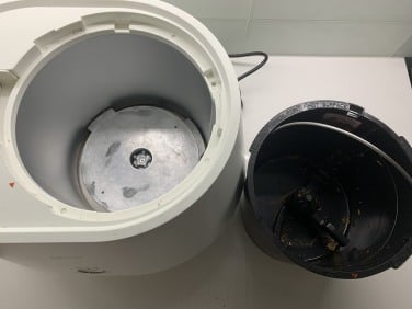 Lomi composter and removed bucket sitting on countertop