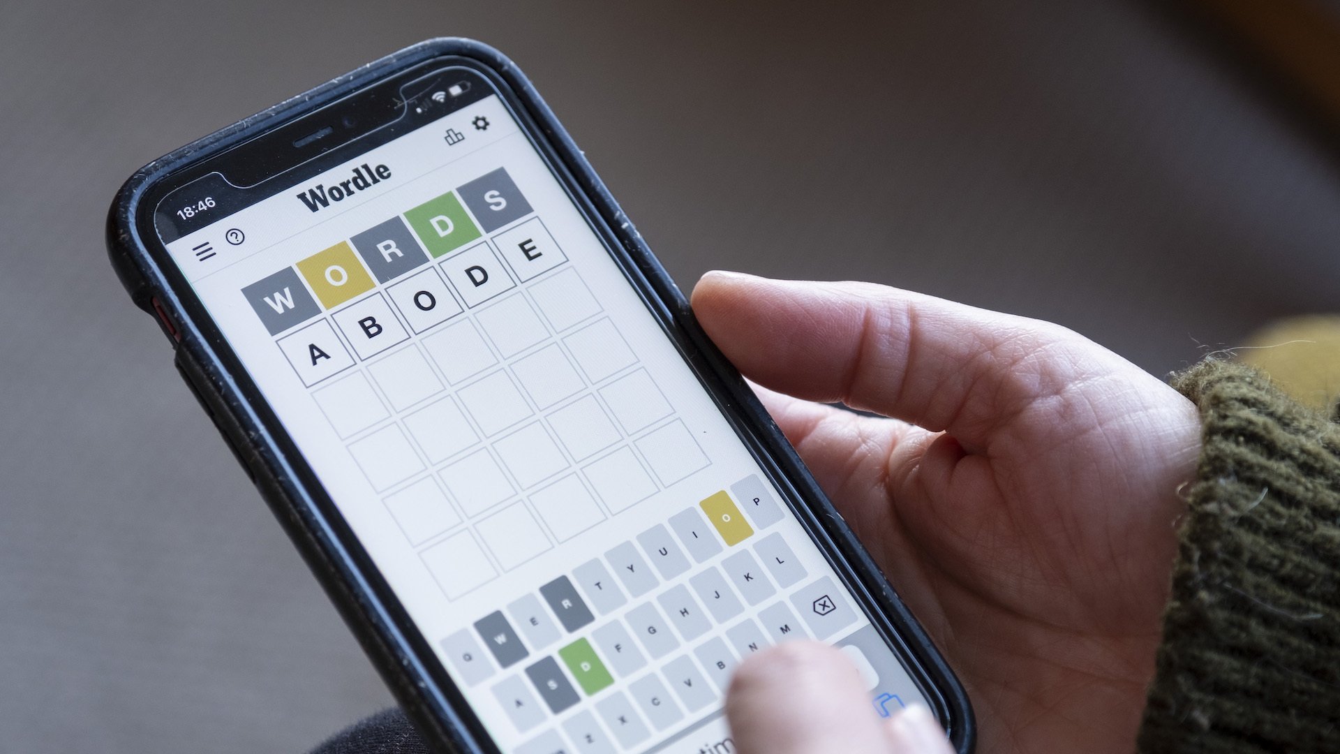 Woman plays Wordle on her smartphone
