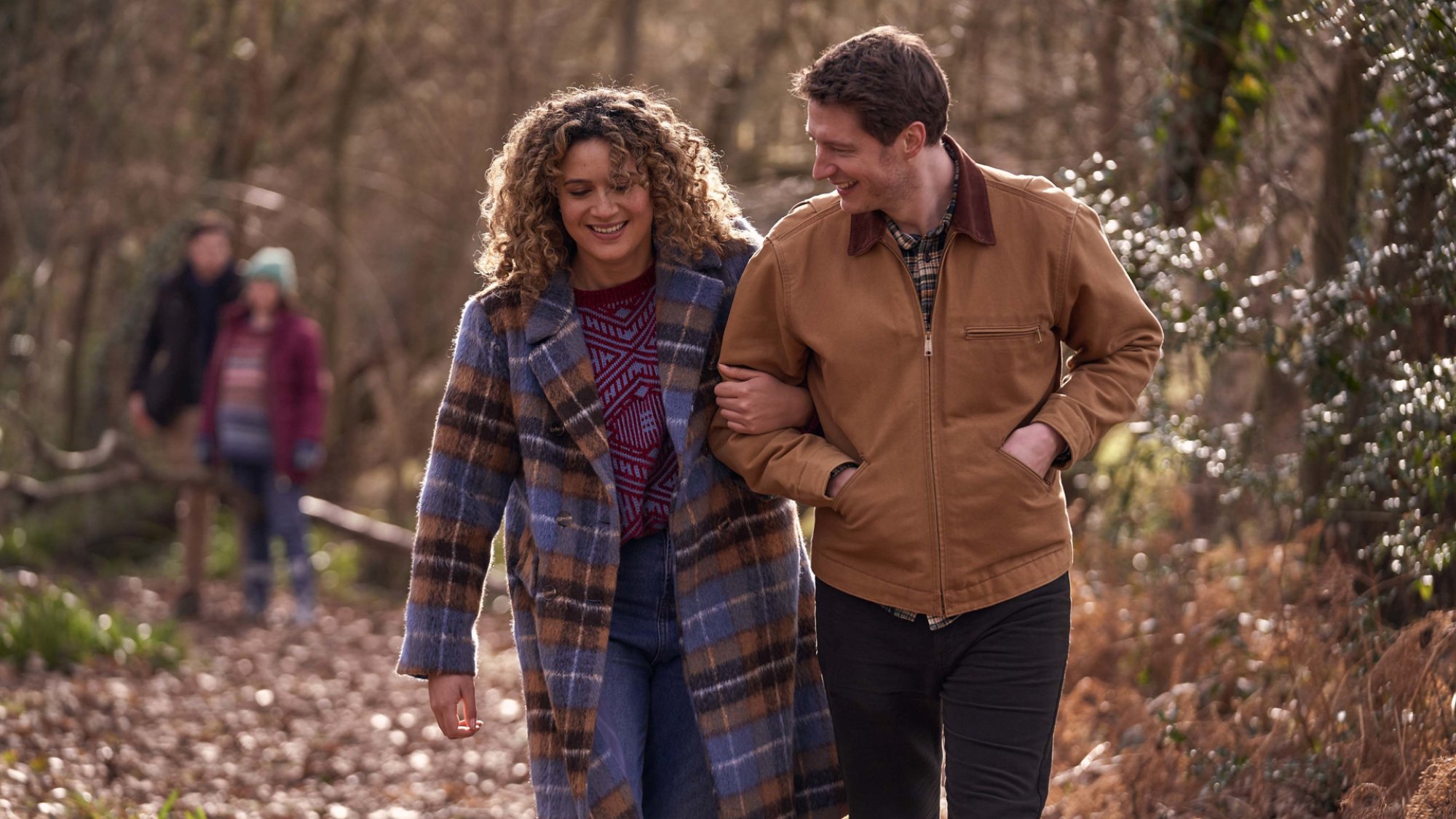 Rose Matafeo and Lorne MacFadyen stroll through the woods arm in arm in the TV show "Starstruck"
