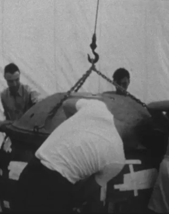 Oppenheimer, on left, helps during the final assembly of the first detonated atomic bomb, called "the gadget."