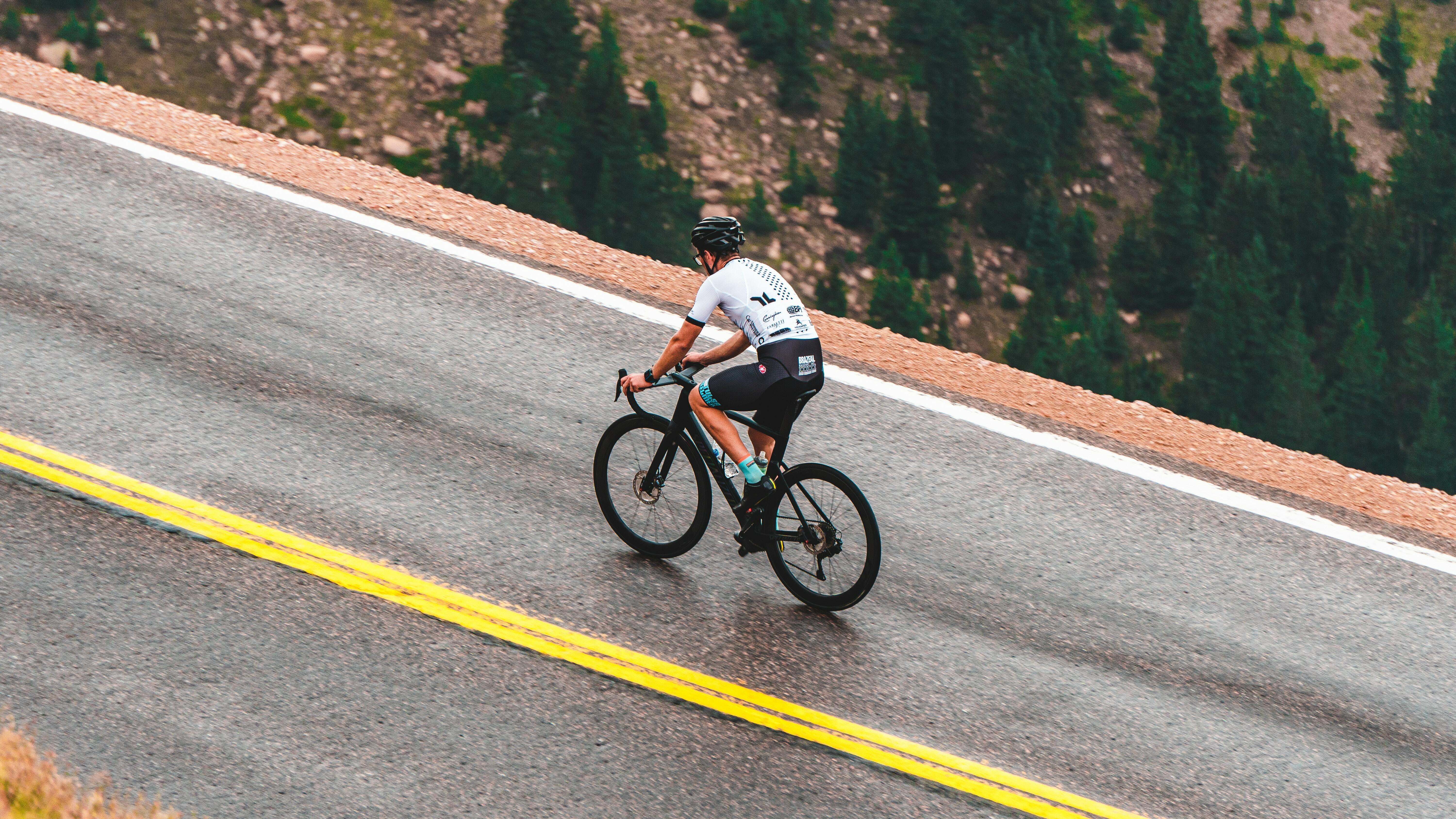 The pack of riders cycles past a two men steering a gondola