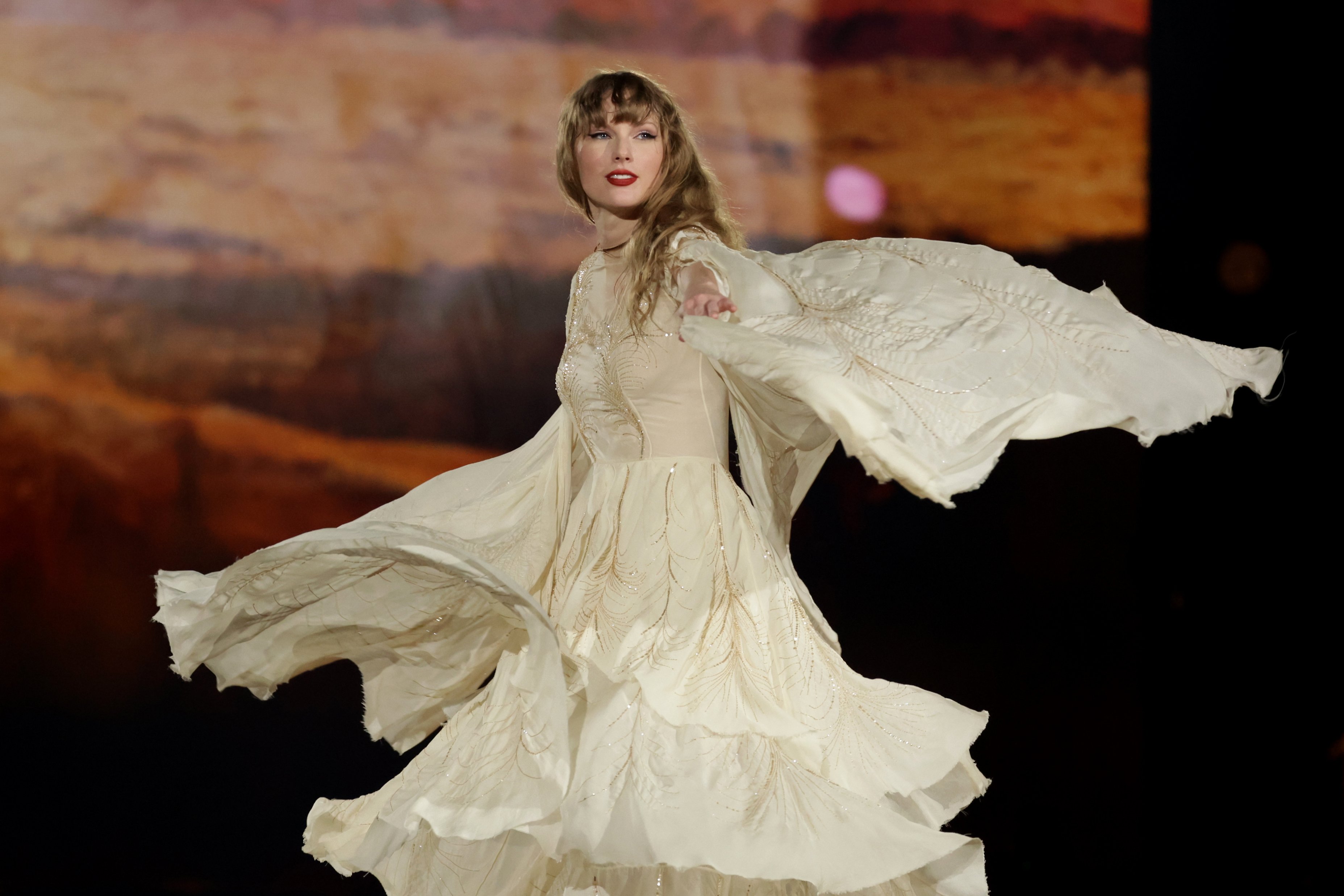 Taylor Swift performing in a gauzy white dress. 