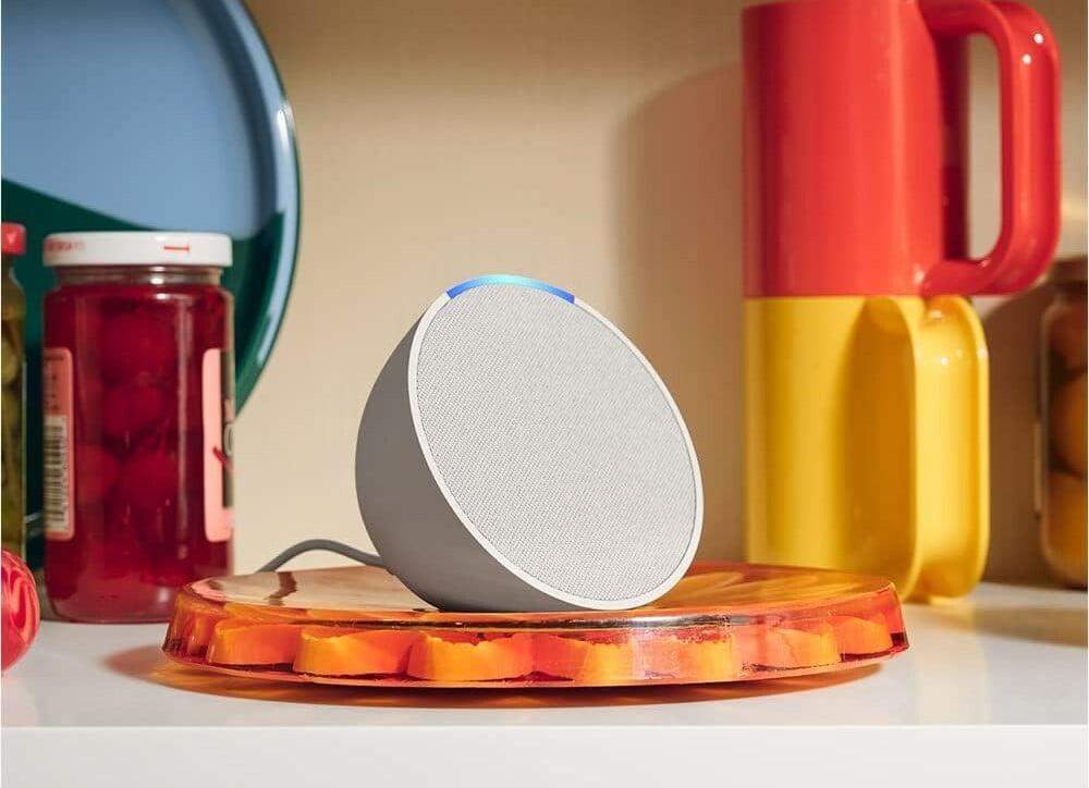 an echo pop sits on a kitchen counter top with colorful mugs in the background