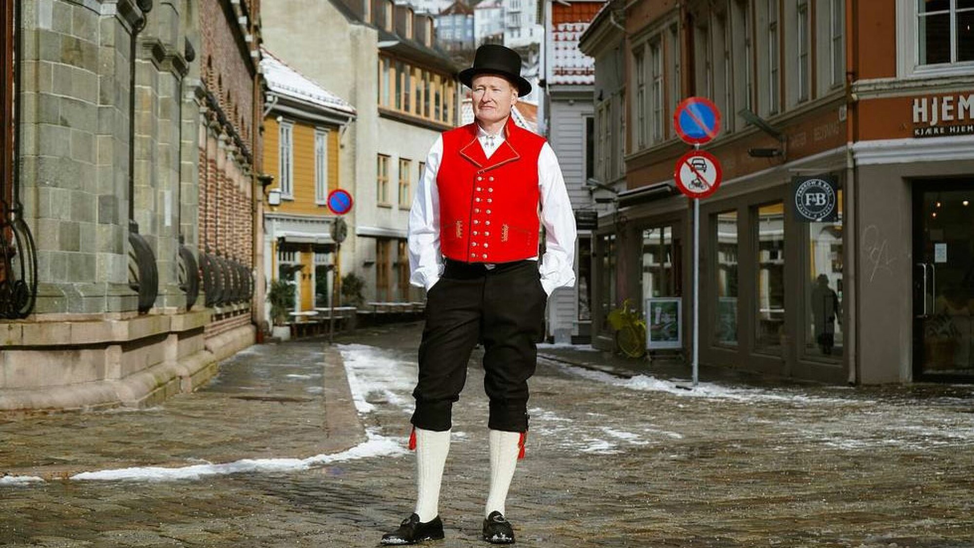 A man in a strange outfit stands in the street.