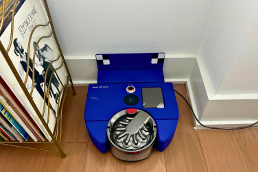 Dyson 360 Vis Nav sitting against wall with record shelf beside it