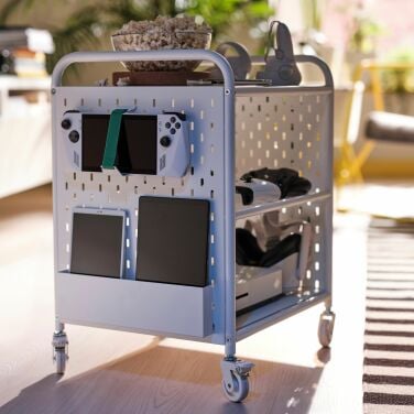 A white rolling storage castor stores gaming tech and accessories.