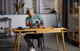 A man sits at a desk holding the Emperor's Throne Room™ Diorama