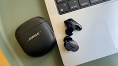 Black Bose headphones next to a laptop on a green background