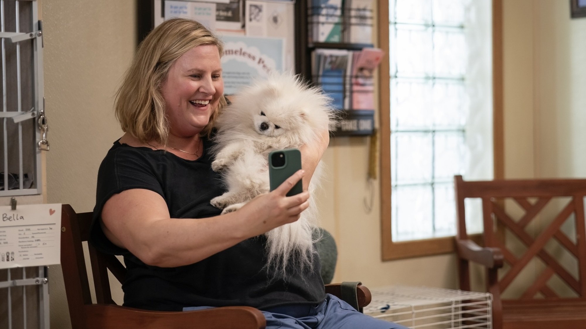 Sam takes a selfie with a little white Pomeranian in "Somebody Somewhere."