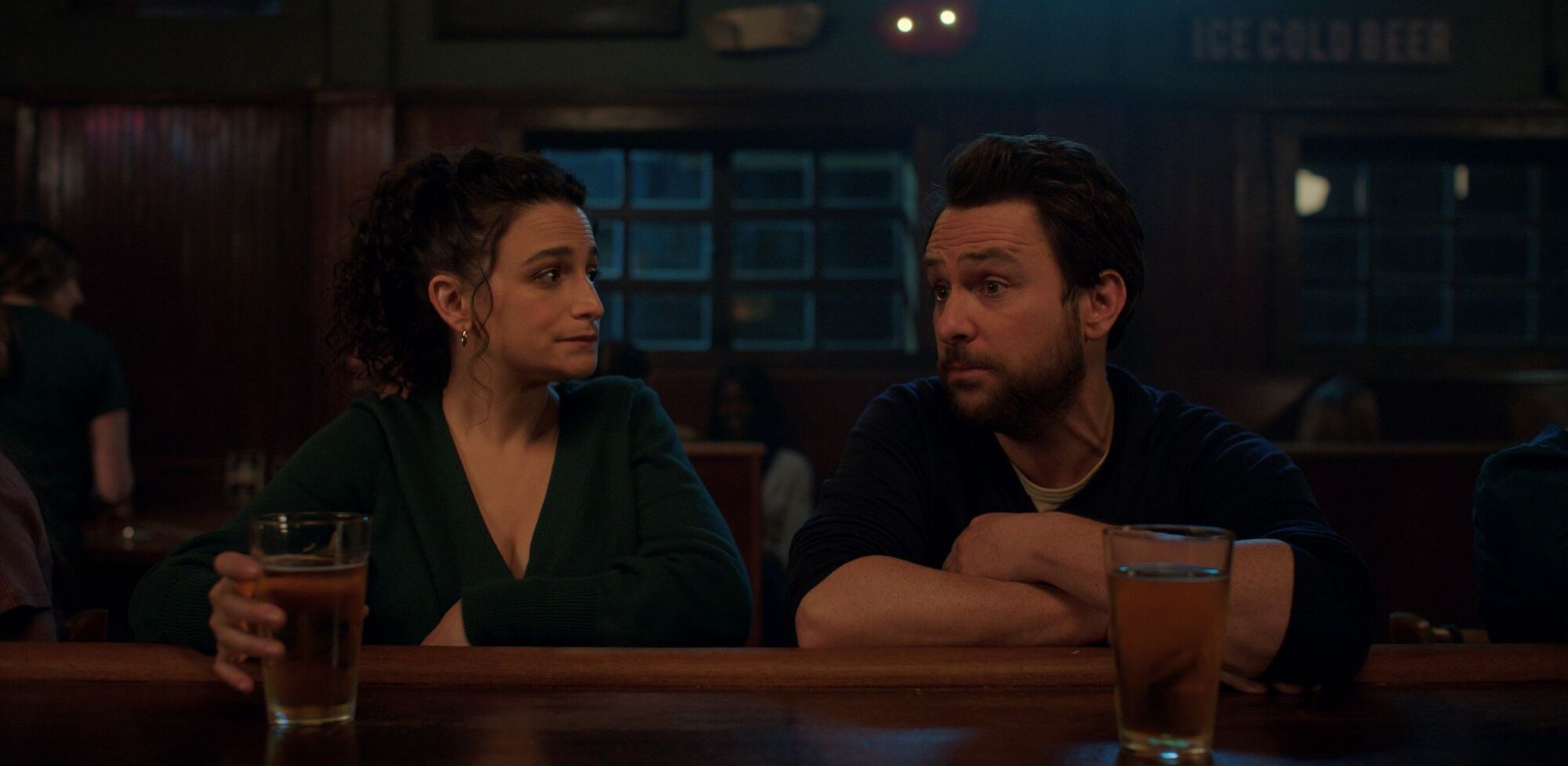 Jenny Slate and Charlie Day sit at a bar in this still from the movie "I Want You Back."