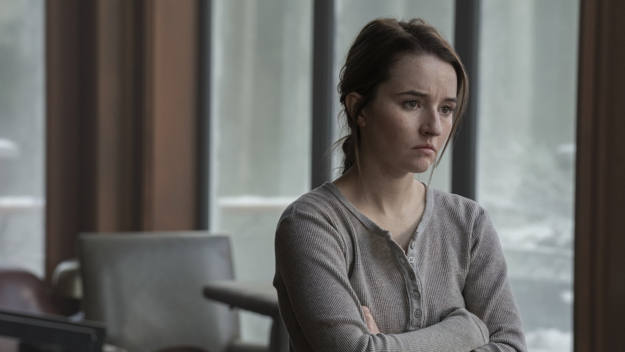 Kaitlyn Dever looks out a window as Abby in "The Last of Us."