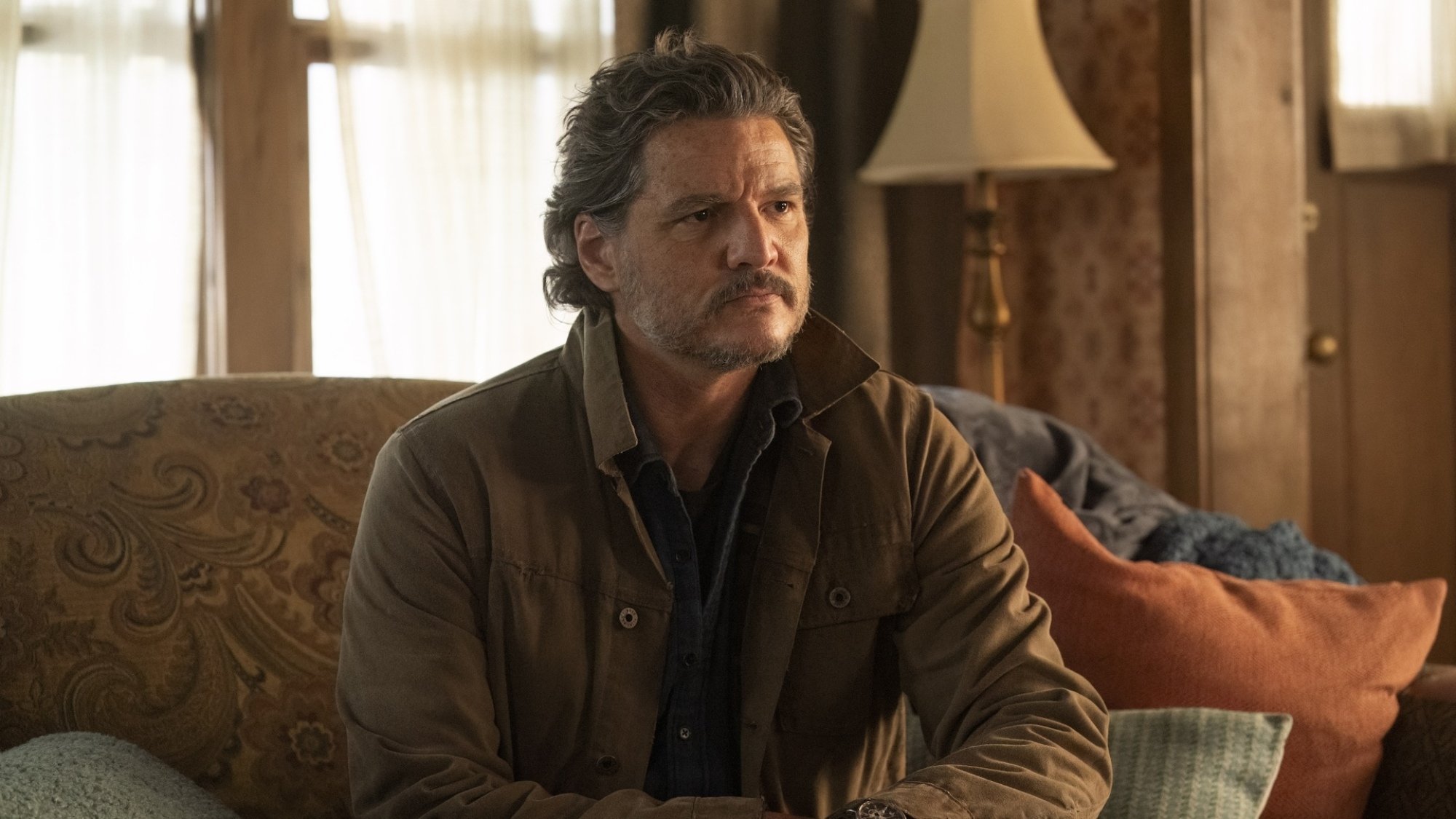 Pedro Pascal sits on a couch as Joel in "The Last of Us."