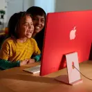 Two people looking at an iMac desktop