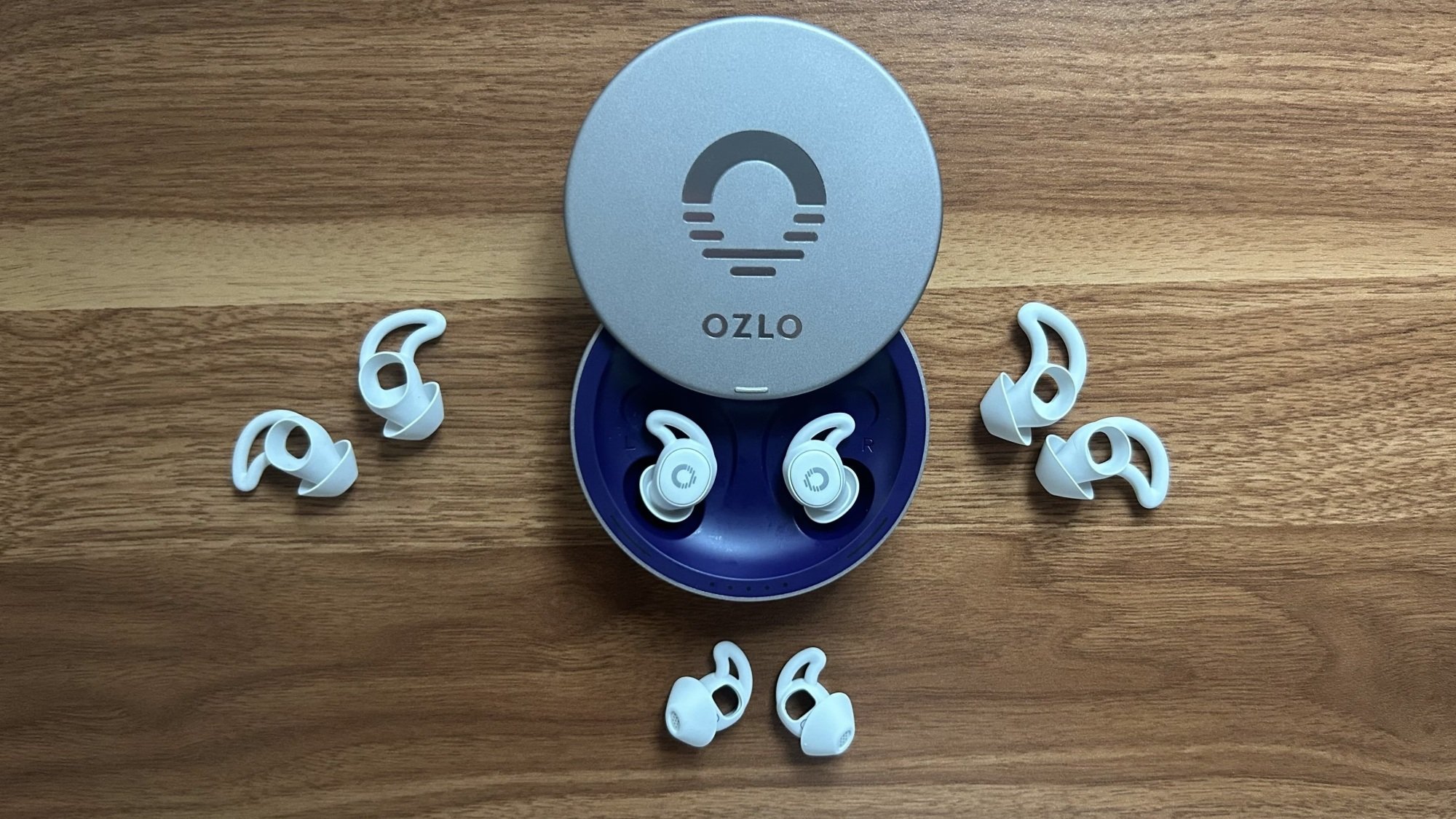 ozlo earbuds on desk with wing tip sizes