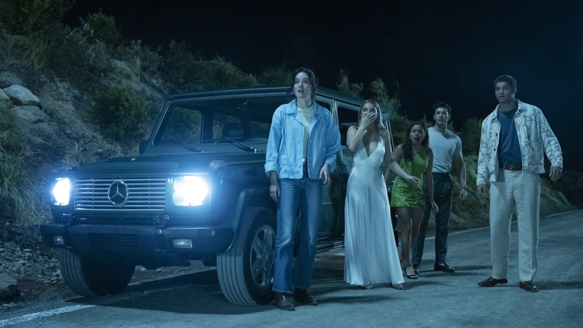 The cast of "I Know What You Did Last Summer" stares down a hill where the barrier has broken.